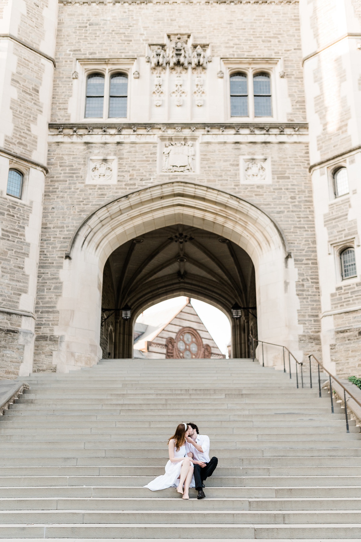 A candid moment captured as Page and Christopher share a loving kiss beneath a Princeton University arch.