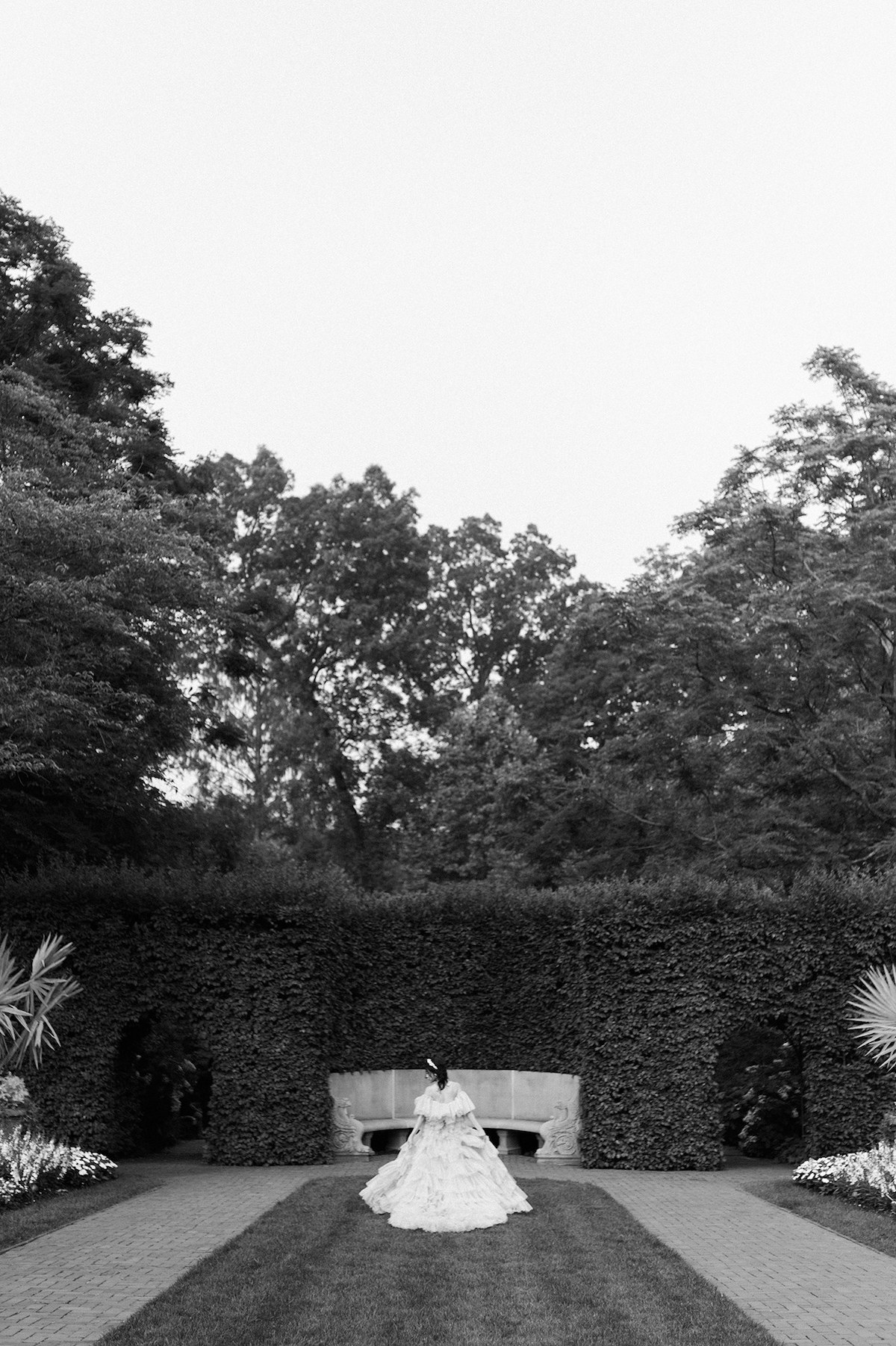 A captivating black and white image capturing the bride's grace and elegance as she dons the tiered couture gown against the backdrop of Longwood Gardens.