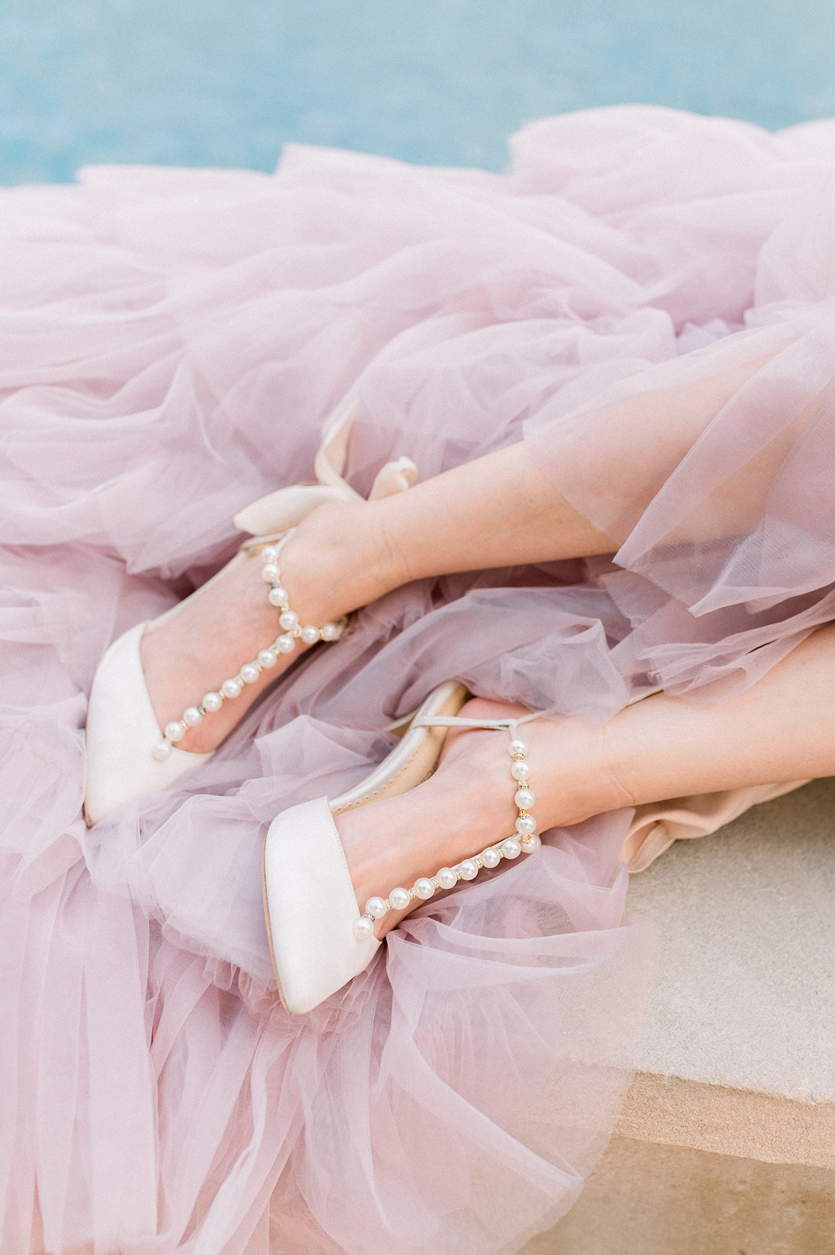 Pearl-accented Bella Belle shoes, a luxurious and stylish choice to complete the bridal look, captured in detail.
