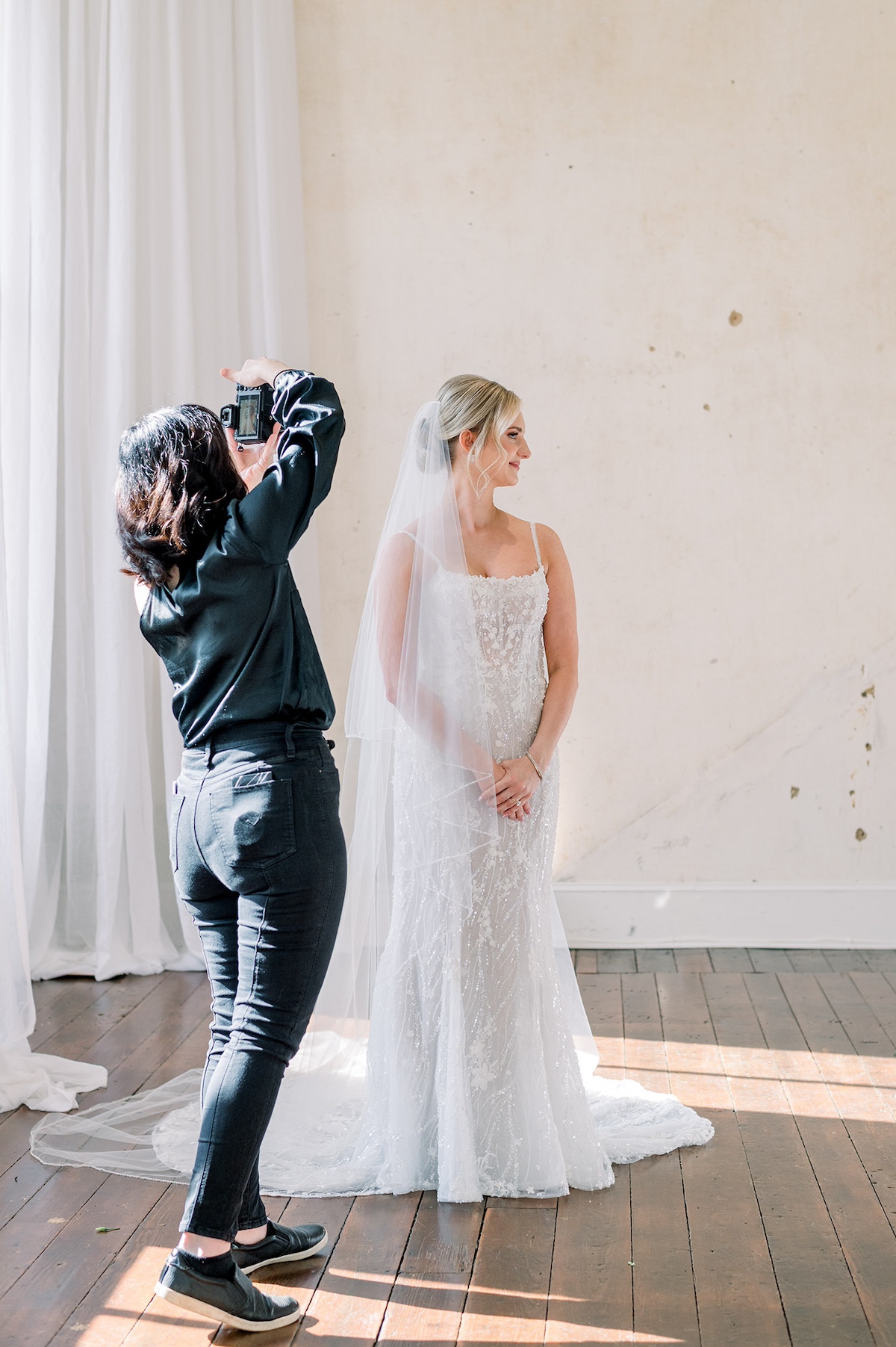 A sneak peek behind the scenes as the photographer, immersed in creative focus, captures the intimate and candid moments of Kelly and Adam's wedding.