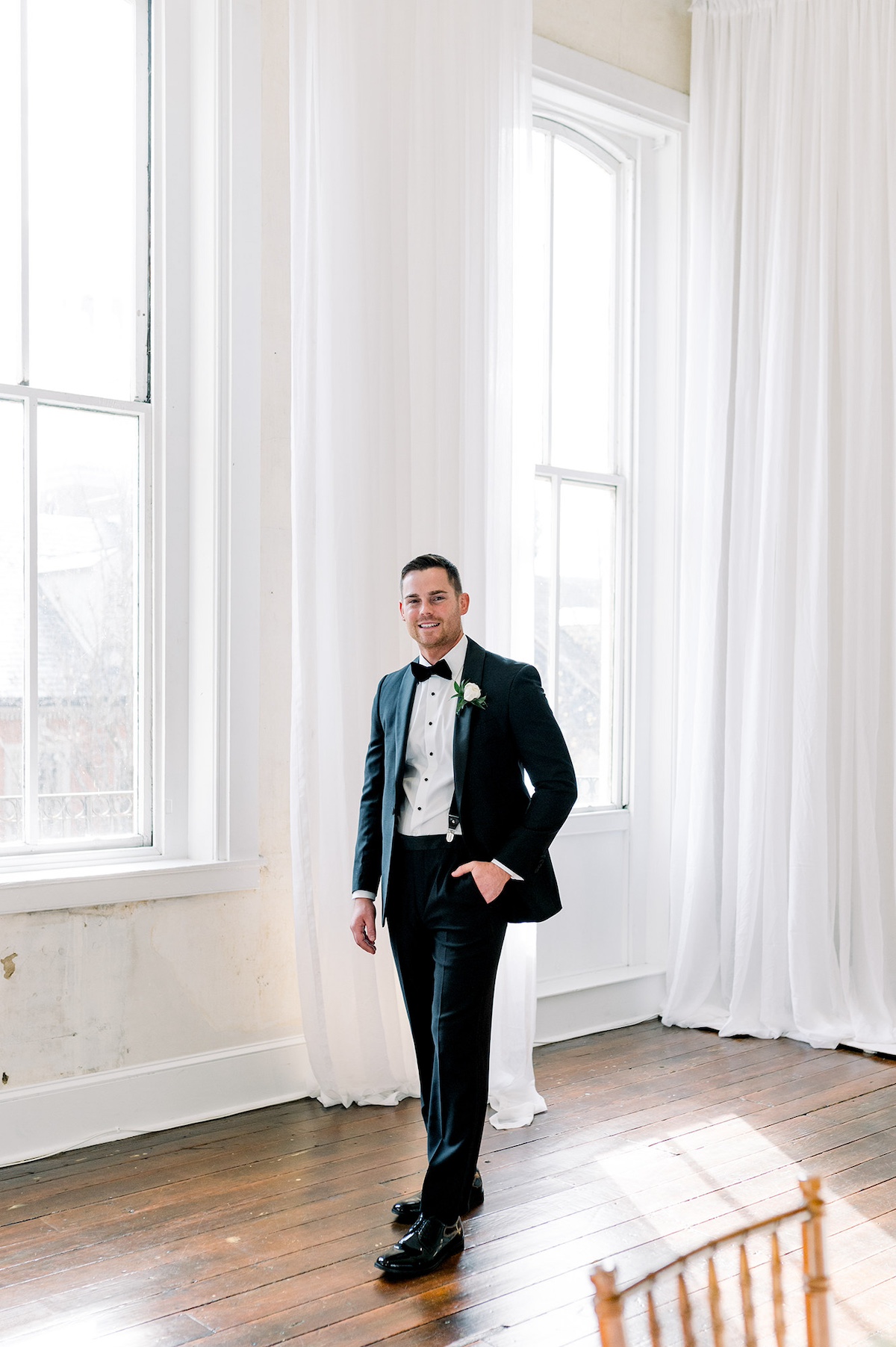 Editorial capture of the groom in a moment of joyful celebration, adding an element of festivity and high-end charm to the occasion.