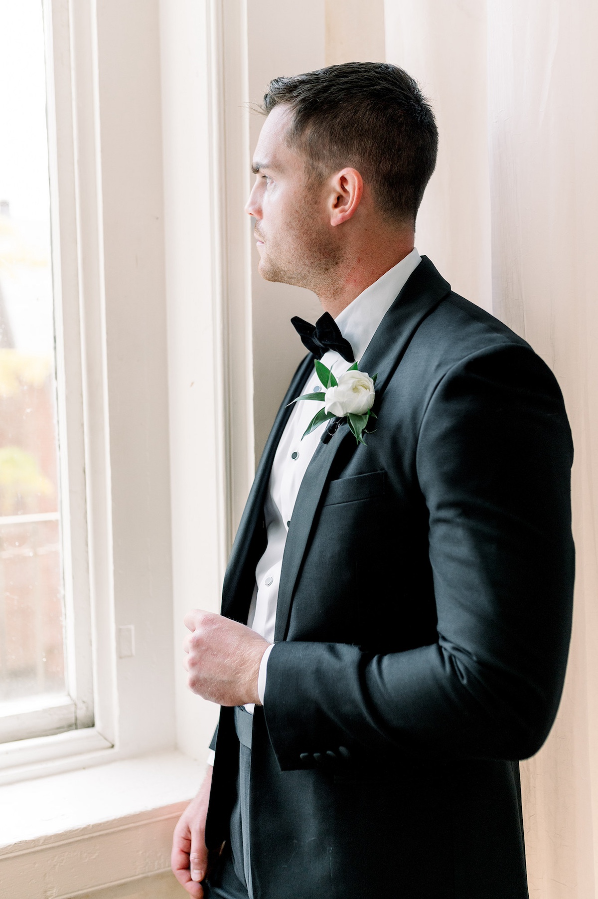 A reflective editorial moment featuring the groom, expressing a blend of contemplation and high-end sophistication.