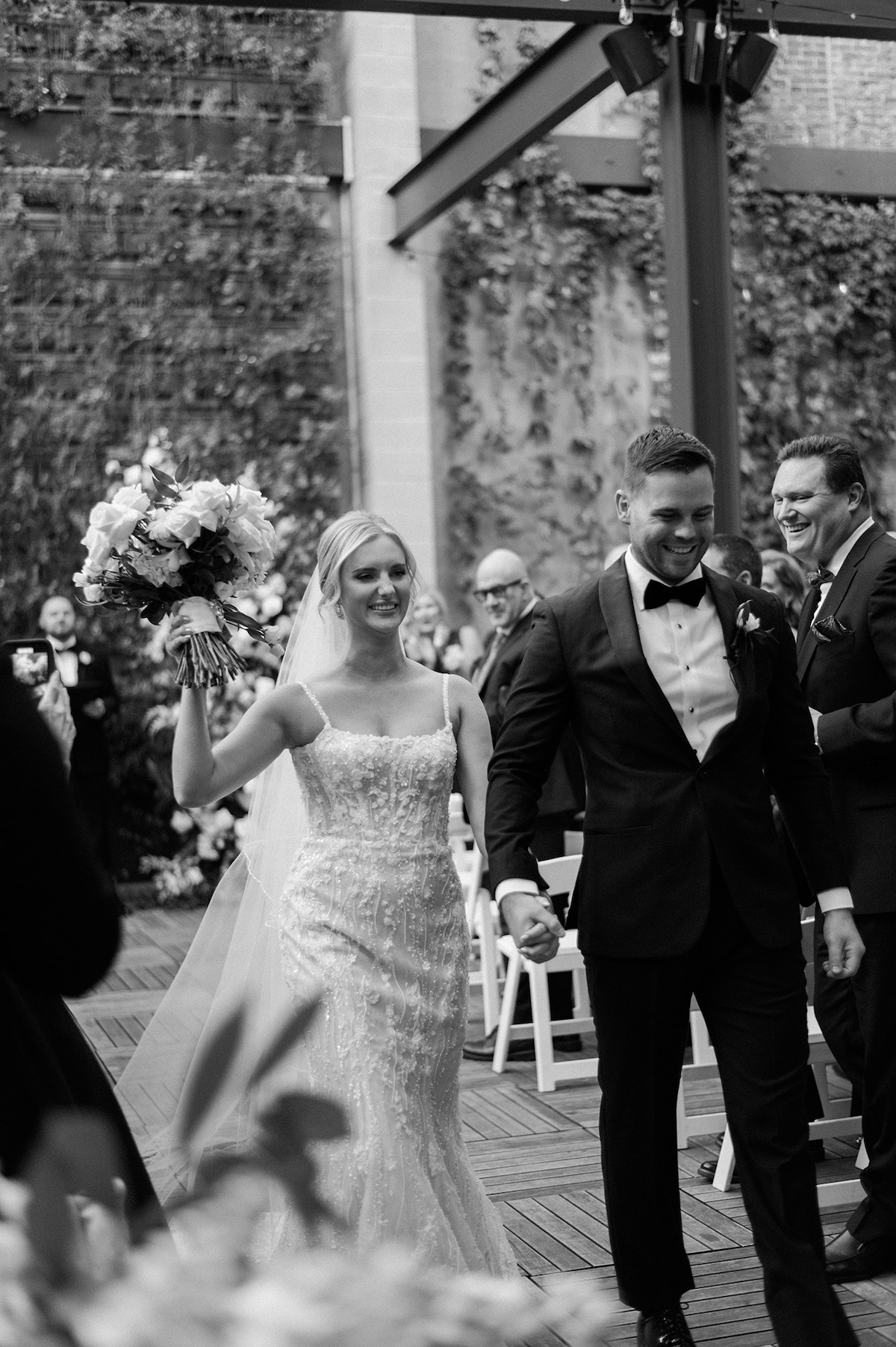 Captivating editorial moment of the bride during the recessional, showcasing her excitement and high-end celebration.