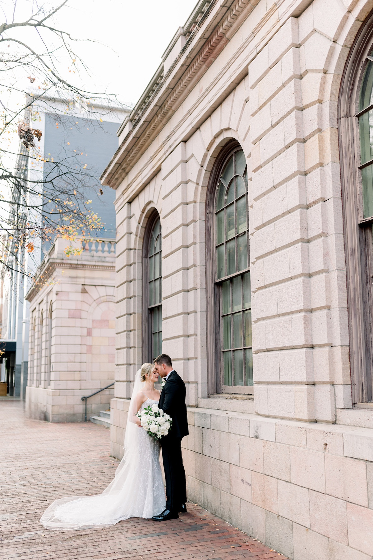 Iconic landmarks of Lancaster City frame an editorial portrait of the bride and groom, epitomizing their high-end love story against cityscapes.